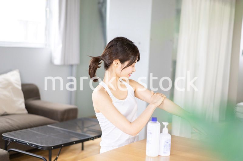 腕にクリームを塗る若い女性