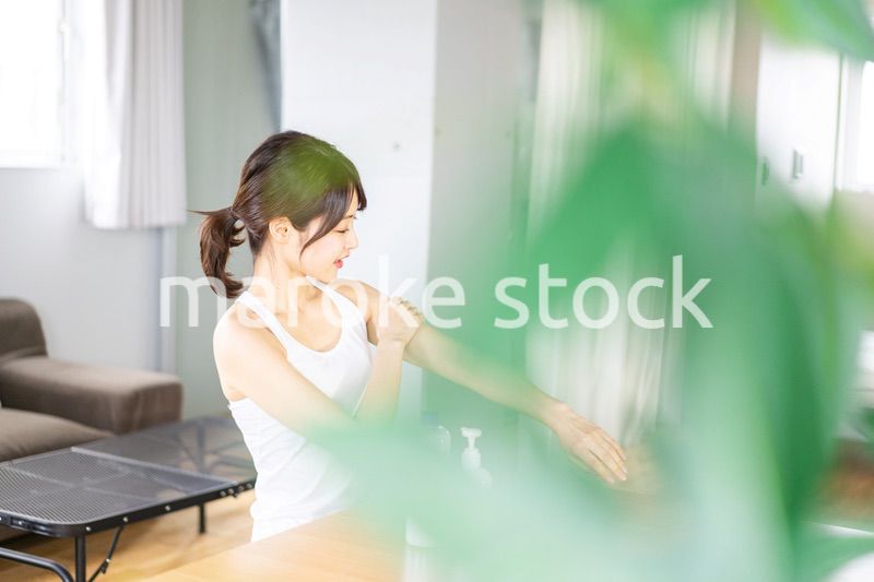 腕にクリームを塗る若い女性