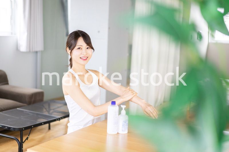 腕にクリームを塗る若い女性