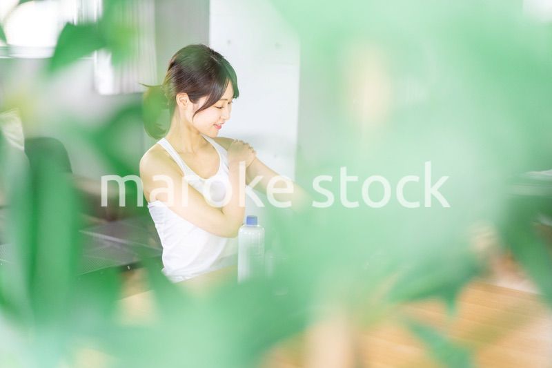 腕にクリームを塗る若い女性