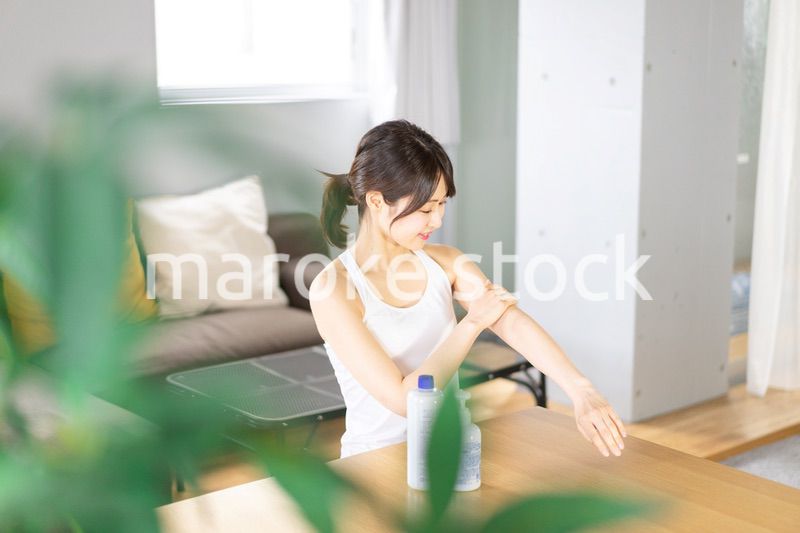 腕にクリームを塗る若い女性