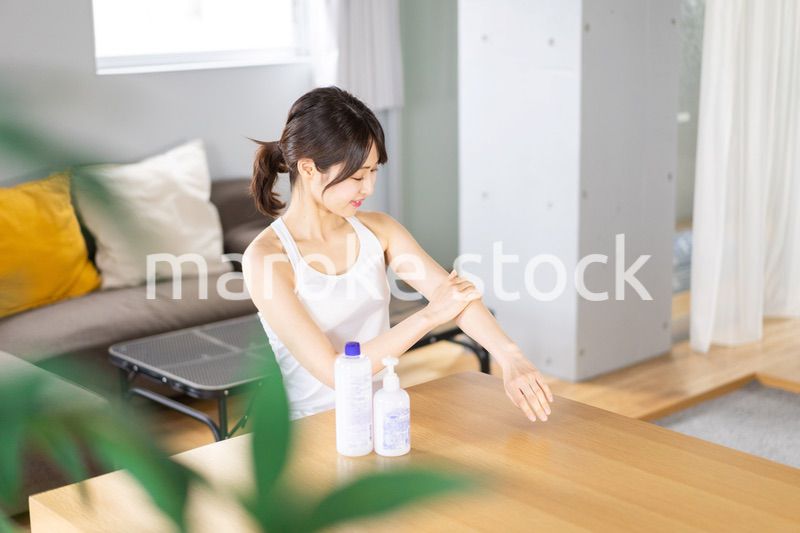 腕にクリームを塗る若い女性