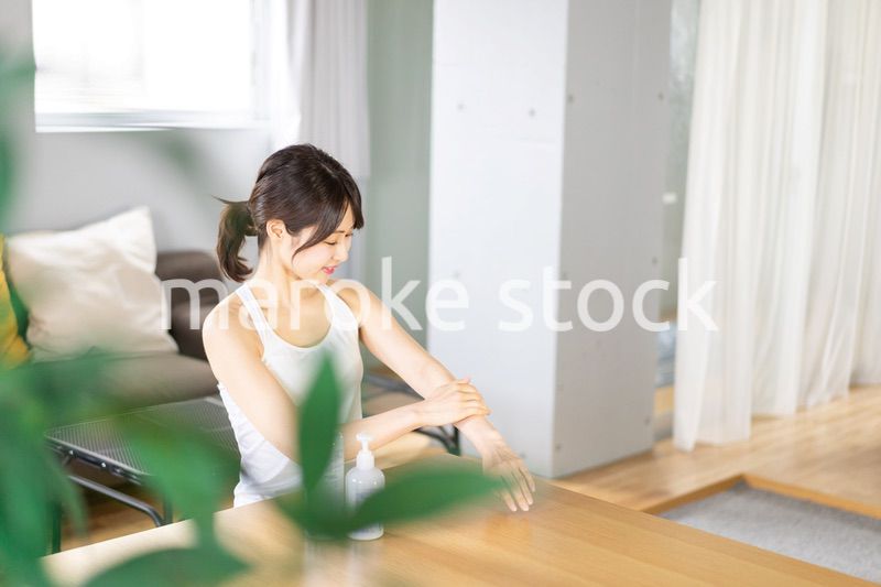 腕にクリームを塗る若い女性