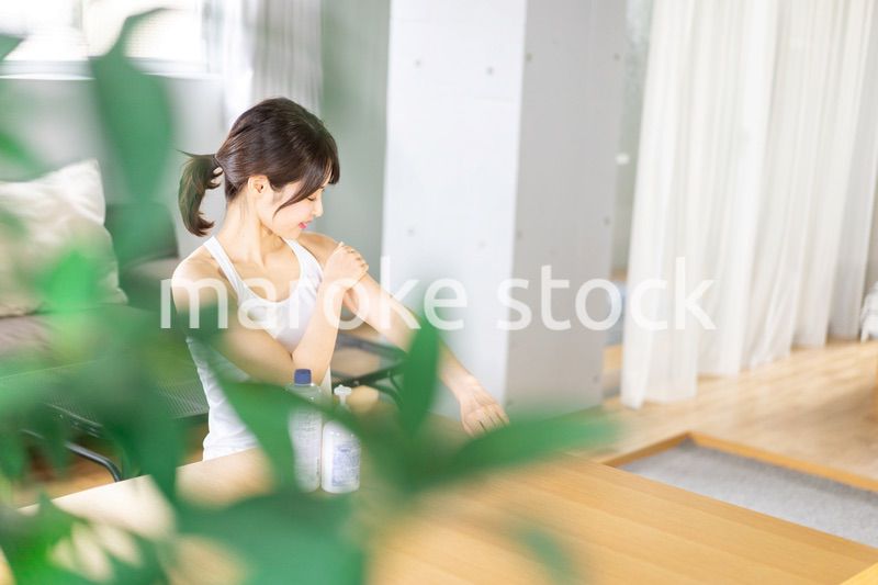 腕にクリームを塗る若い女性