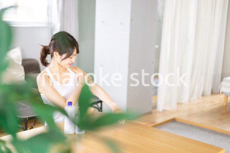 腕にクリームを塗る若い女性