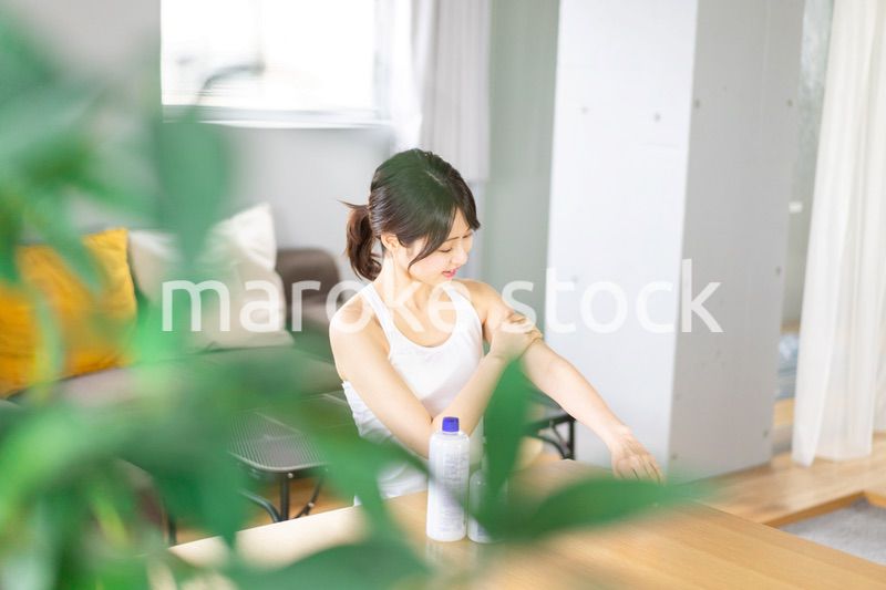 腕にクリームを塗る若い女性