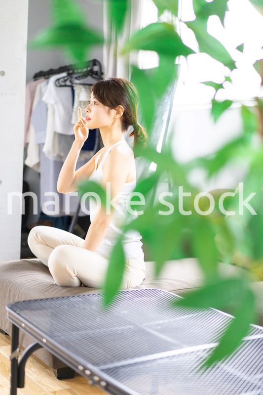 部屋でスキンケアをする若い女性