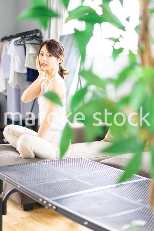 部屋でスキンケアをする若い女性