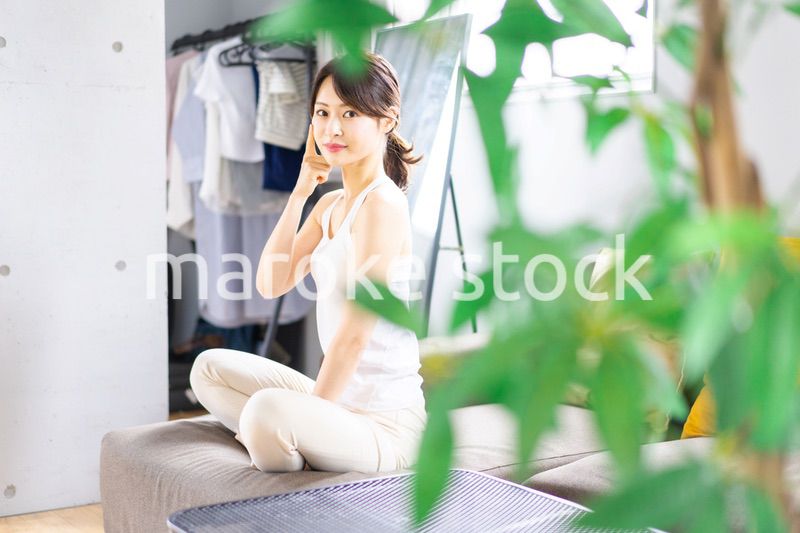 部屋でスキンケアをする若い女性