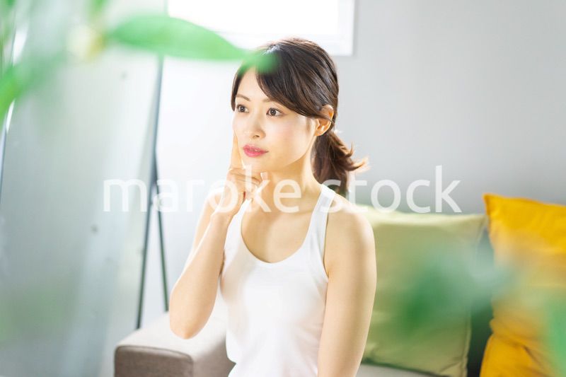 部屋でスキンケアをする若い女性