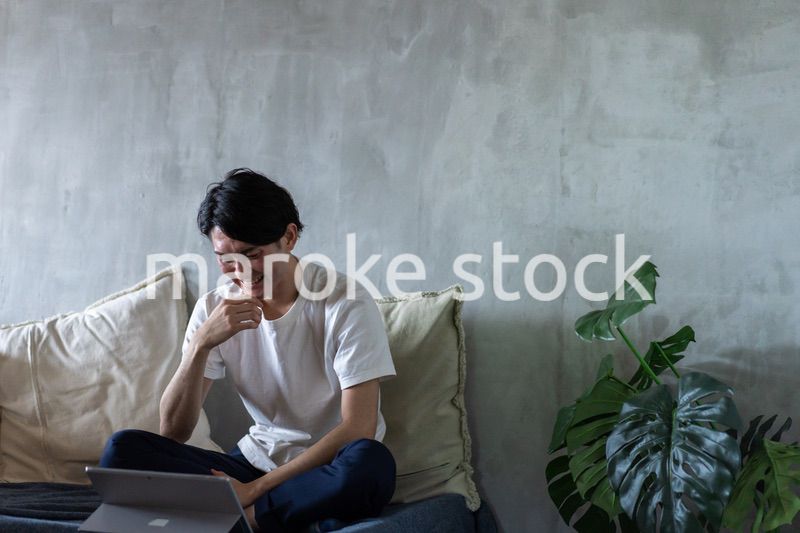 ベッドで在宅勤務をする若い男性