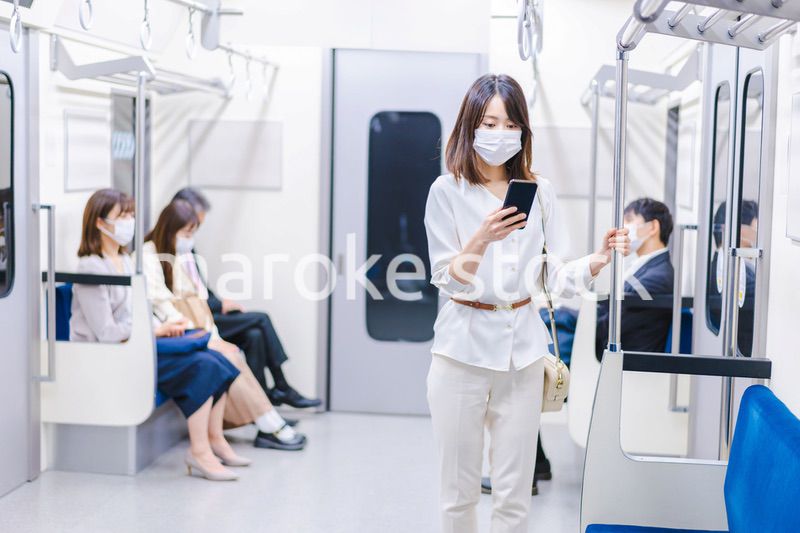マスクをして電車にのる女性