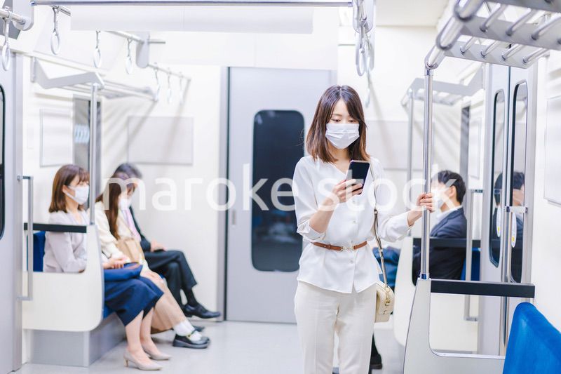 マスクをして電車にのる女性