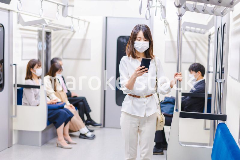 マスクをして電車にのる女性