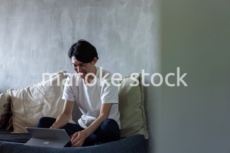 ベッドで在宅勤務をする若い男性