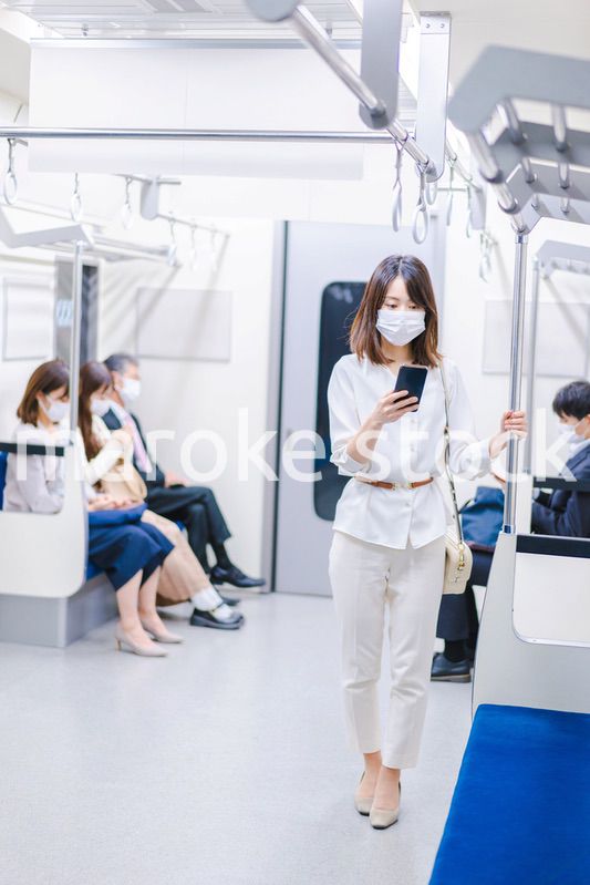 マスクをして電車にのる女性
