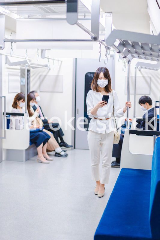マスクをして電車にのる女性