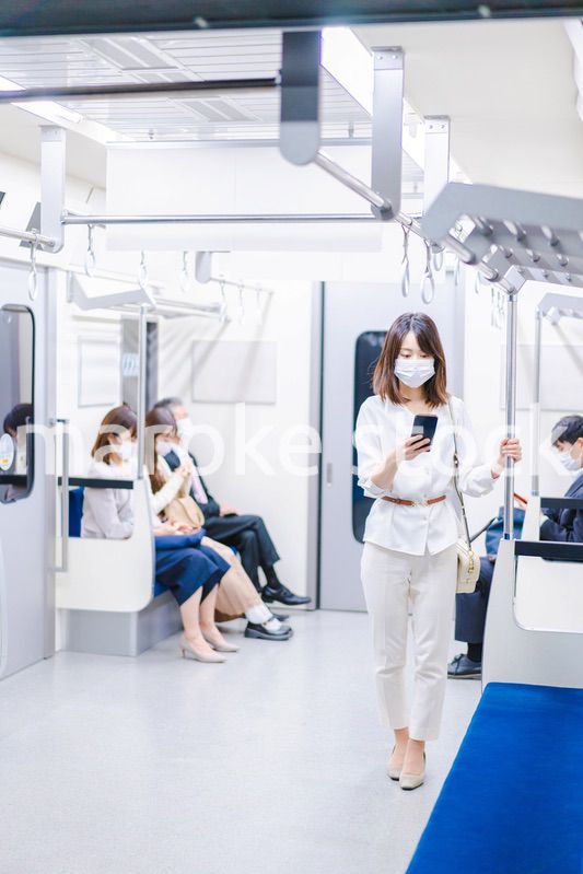 マスクをして電車にのる女性