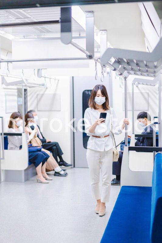 マスクをして電車にのる女性