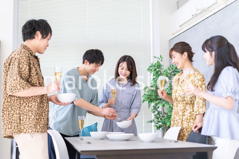 みんなで食事をする若い男女