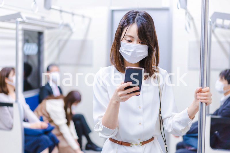 マスクをして電車にのる女性