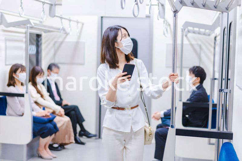 マスクをして電車にのる女性