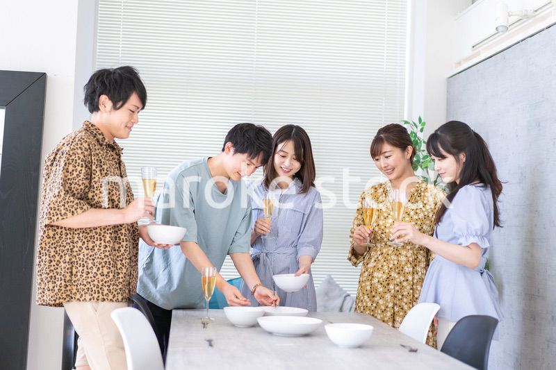 みんなで食事をする若い男女