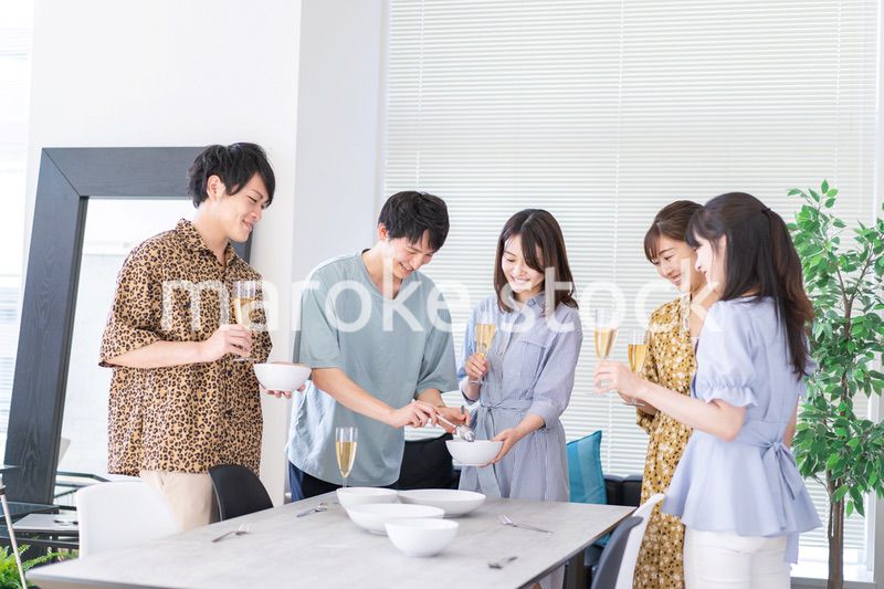 みんなで食事をする若い男女