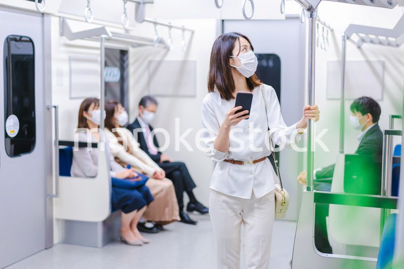 マスクをして電車にのる女性