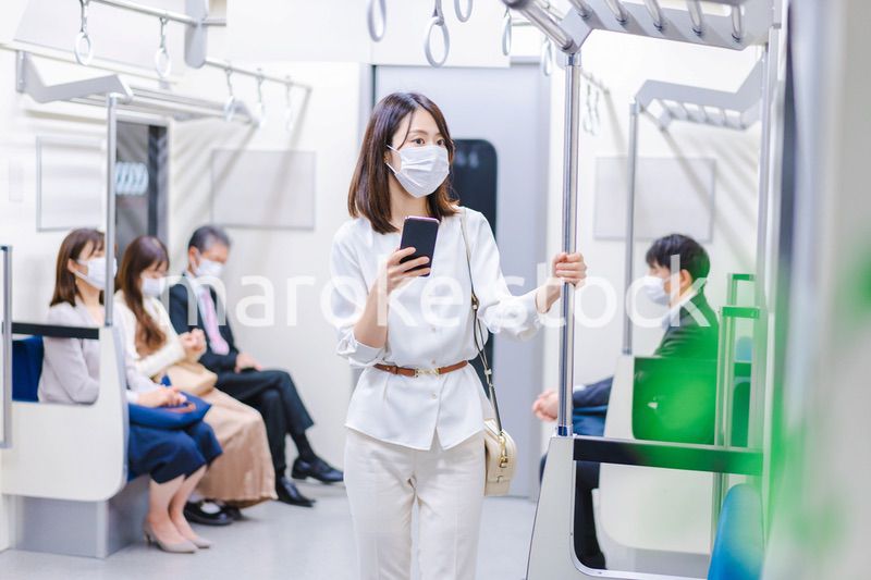 マスクをして電車にのる女性