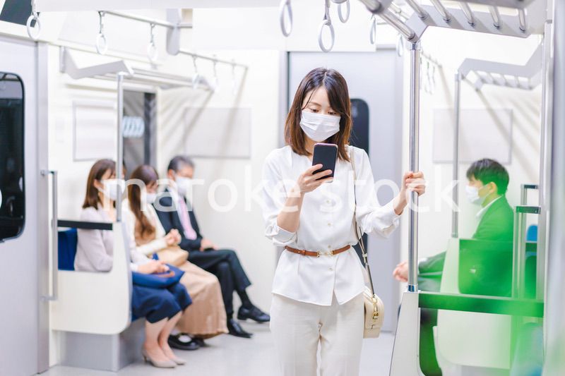 マスクをして電車にのる女性