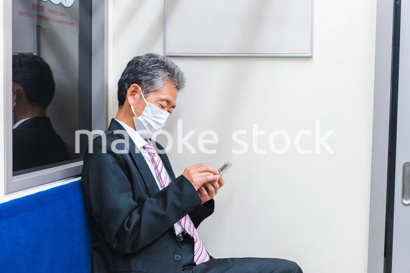 電車でスマホを使う社長