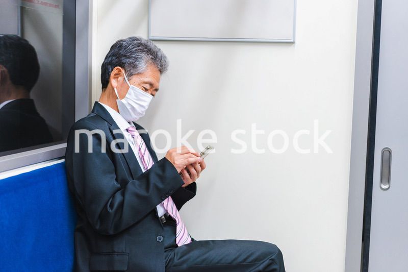 電車でスマホを使う社長