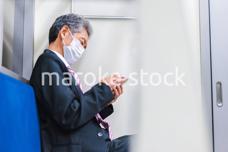 電車でスマホを使う社長