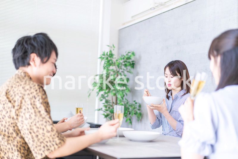 みんなで食事をする若い男女