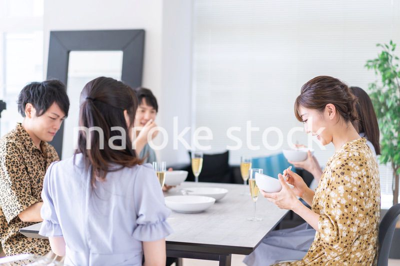 みんなで食事をする若い男女