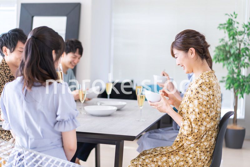 みんなで食事をする若い男女