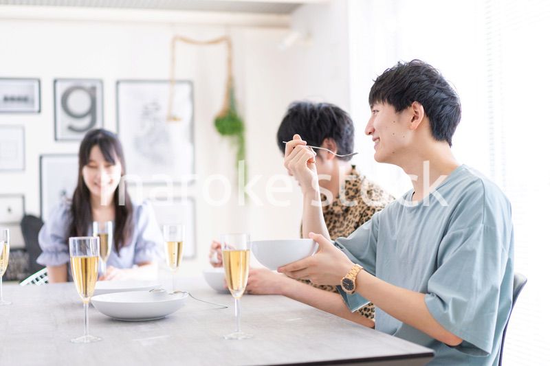 みんなで食事をする若い男女