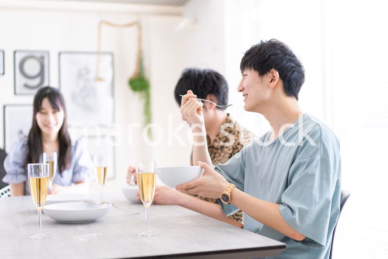 みんなで食事をする若い男女