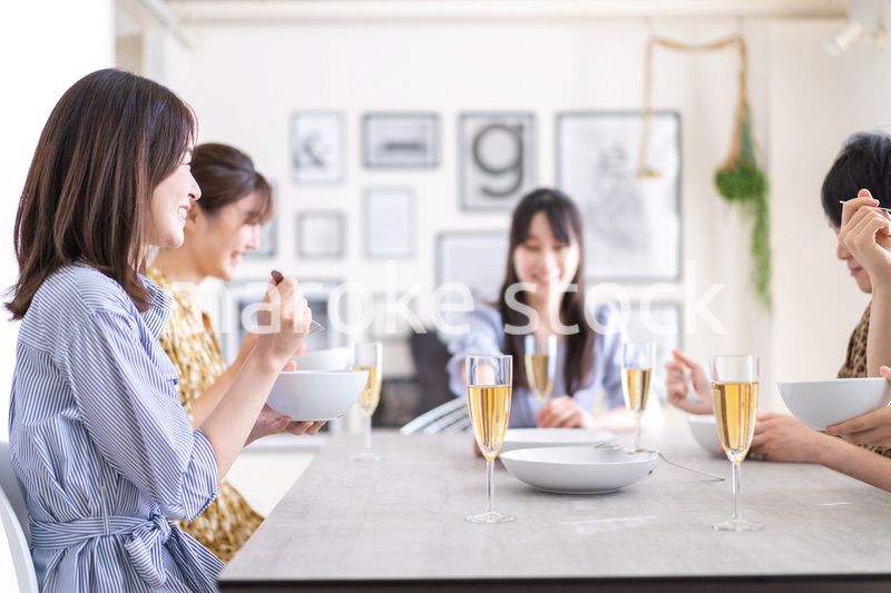 みんなで食事をする若い男女