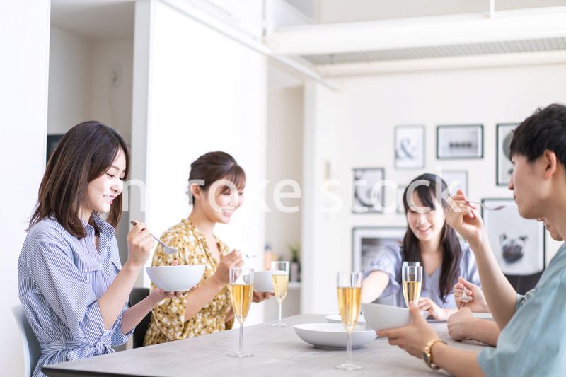 みんなで食事をする若い男女
