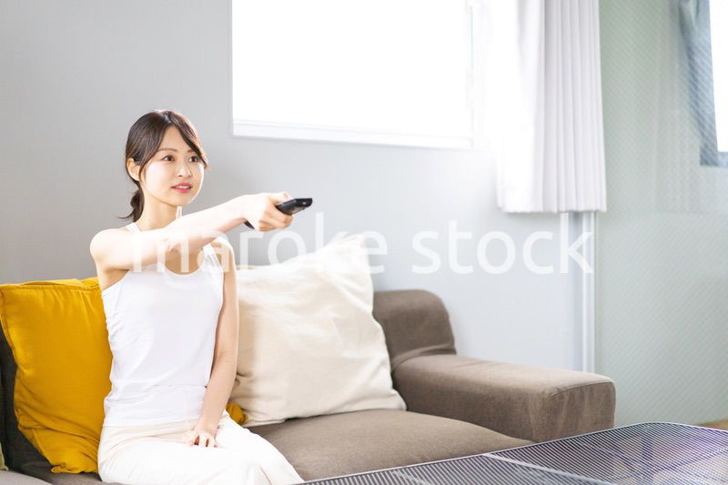家でテレビを見る若い女性
