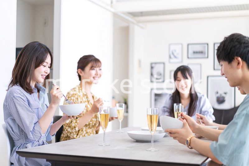 みんなで食事をする若い男女