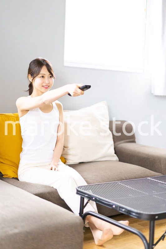 家でテレビを見る若い女性