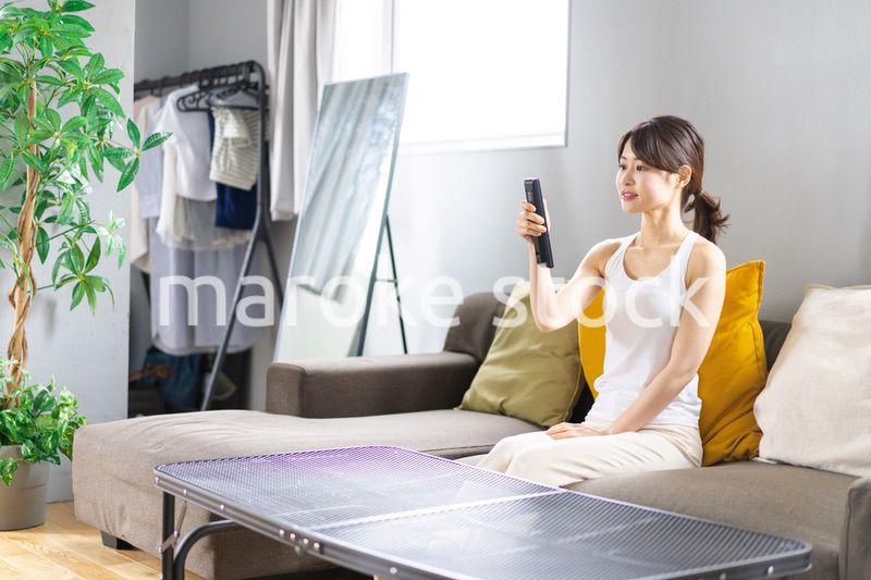 家でテレビを見る若い女性