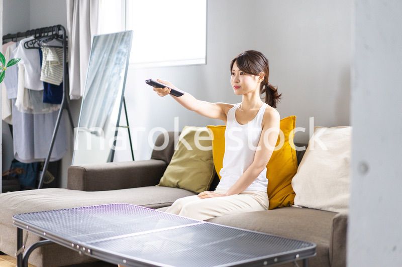家でテレビを見る若い女性