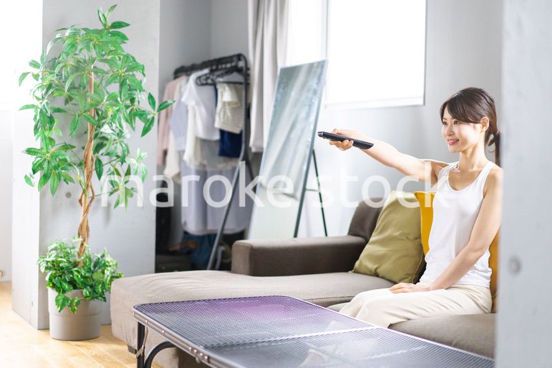 家でテレビを見る若い女性