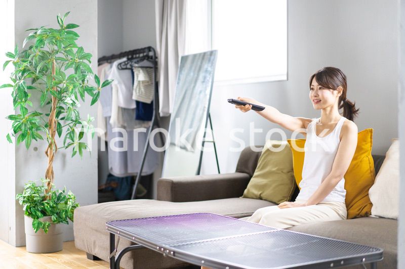家でテレビを見る若い女性