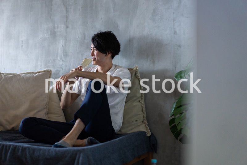 一人で宅飲みをする若い男性