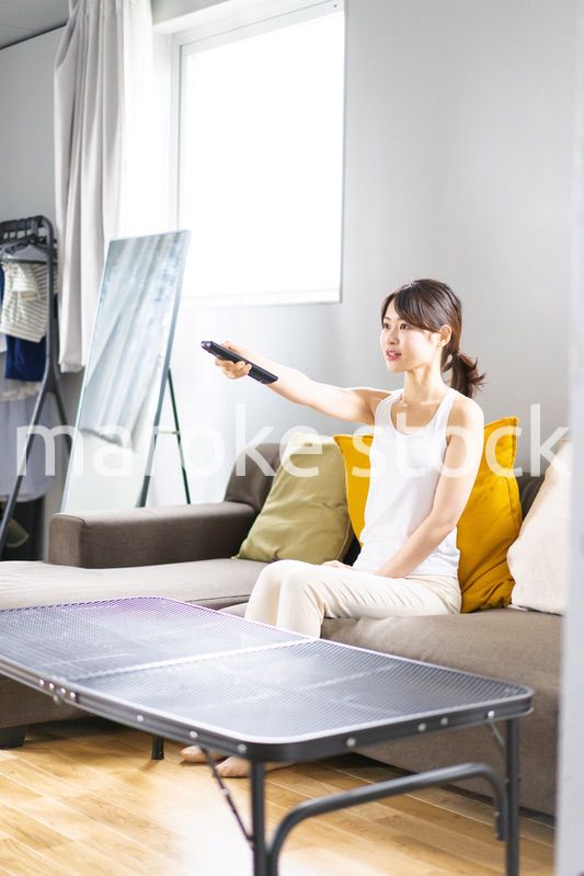 家でテレビを見る若い女性